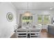 Bright dining area with a chandelier, table with seating for six, wood floors, and view of the backyard at 80 Spotted Bee Way, Youngsville, NC 27596