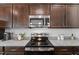 Kitchen with granite countertops, stainless appliances, and dark wood cabinetry at 80 Spotted Bee Way, Youngsville, NC 27596
