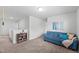 Cozy loft with a comfortable blue sofa, soft carpet, and lots of natural light at 80 Spotted Bee Way, Youngsville, NC 27596