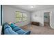 Bright loft area with neutral walls, plush carpet, natural light, and a comfortable blue sofa at 80 Spotted Bee Way, Youngsville, NC 27596