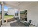 Covered porch with chairs and a table, offering a cozy outdoor space with access to the backyard through sliding glass doors at 80 Spotted Bee Way, Youngsville, NC 27596