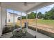 Screened porch with green metal chairs and a table, providing a relaxing outdoor space with a view of the backyard at 80 Spotted Bee Way, Youngsville, NC 27596