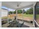 Relaxing screened porch features a ceiling fan, view of the backyard, and comfortable seating area at 80 Spotted Bee Way, Youngsville, NC 27596
