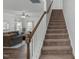 Staircase leading to a living room with a ceiling fan and carpeted stairs at 80 Spotted Bee Way, Youngsville, NC 27596
