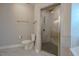 Bright bathroom featuring a glass-enclosed shower with grid floor, toilet, and neutral wall color at 800 Gathering Park Cir # 204, Cary, NC 27519