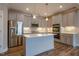 Modern kitchen featuring stainless steel appliances, gray cabinets, and a center island with pendant lighting at 800 Gathering Park Cir # 204, Cary, NC 27519