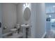 Half bathroom featuring a pedestal sink, toilet, and mirror, located near the kitchen area at 800 Gathering Park Cir # 204, Cary, NC 27519