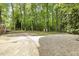 Spacious backyard features a driveway, parking area, and outbuilding in wooded area at 814 Ellynn Dr, Cary, NC 27511