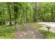 Picturesque backyard with mature trees and a pathway leading to a storage shed at 814 Ellynn Dr, Cary, NC 27511