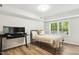Well-lit bedroom with hardwood floors, neutral walls, a comfortable bed, and a serene outdoor view at 814 Ellynn Dr, Cary, NC 27511