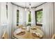 Bright dining area with a round wooden table, wicker chairs, and sheer curtains for natural light at 814 Ellynn Dr, Cary, NC 27511
