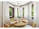 Bright dining area featuring a wooden table with wicker chairs, surrounded by windows with sheer curtains at 814 Ellynn Dr, Cary, NC 27511