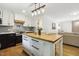 Open concept kitchen with butcher block island, stainless appliances, and black lower cabinets at 814 Ellynn Dr, Cary, NC 27511