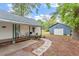Backyard features stone pathway, covered back porch with seating, and large storage building at 820 Southern St, Selma, NC 27576