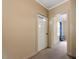 Hallway with neutral walls, trim, carpeting, and door with inset windows leading to the next room at 820 Southern St, Selma, NC 27576