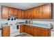 Traditional kitchen with wooden cabinetry, white appliances, and blue countertops at 820 Southern St, Selma, NC 27576