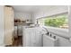 Bright laundry room featuring a modern washer, storage, and a large window offering plenty of natural light at 820 Southern St, Selma, NC 27576