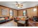 Cozy living room with paneled walls, a ceiling fan, wood floors, neutral colored furniture and natural light from two windows at 820 Southern St, Selma, NC 27576