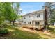 Spacious backyard featuring a wood deck, brick patio, mature trees, and lush green lawn at 8504 Boot Ct, Raleigh, NC 27615