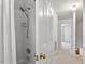 Tiled shower with curtain and showerhead featuring white walls that leads to additional rooms at 8504 Boot Ct, Raleigh, NC 27615