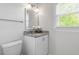 Bright bathroom with a granite countertop, white vanity, and window overlooking the outdoors at 8504 Boot Ct, Raleigh, NC 27615