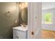 Stylish half bath with modern vanity, gold hardware, and round mirror at 8504 Boot Ct, Raleigh, NC 27615