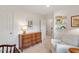 Bedroom featuring a white armchair, wood dresser, book display, and view to hallway at 8504 Boot Ct, Raleigh, NC 27615