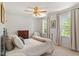 Cozy bedroom with a ceiling fan, two windows, and neutral decor at 8504 Boot Ct, Raleigh, NC 27615