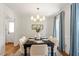 Bright dining room with stylish chandelier, hardwood floors, and elegant blue curtains, perfect for entertaining at 8504 Boot Ct, Raleigh, NC 27615