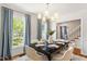Elegant dining room with natural light, modern chandelier, and seating for six, ideal for gatherings and meals at 8504 Boot Ct, Raleigh, NC 27615