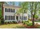 Traditional two-story home featuring black shutters, a covered entryway, and beautifully landscaped front yard at 8504 Boot Ct, Raleigh, NC 27615