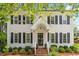 Two-story traditional home with a covered front porch, brick steps, and manicured landscaping at 8504 Boot Ct, Raleigh, NC 27615