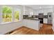 Bright kitchen featuring granite countertops, stainless steel appliances, and white cabinets, with a view to the backyard at 8504 Boot Ct, Raleigh, NC 27615