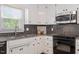 Kitchen with granite countertops, black appliances, tiled backsplash, and ample cabinet space at 8504 Boot Ct, Raleigh, NC 27615