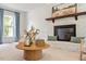 Cozy living room with a white brick fireplace, wooden mantel, and natural light from the large window at 8504 Boot Ct, Raleigh, NC 27615