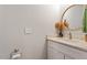 Well-lit half bathroom with a white vanity and round mirror at 905 Carroll St, Durham, NC 27701