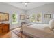 Bright bedroom with a comfortable bed, hardwood floors and large windows at 905 Carroll St, Durham, NC 27701