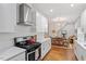 Open kitchen with stainless steel hood, white cabinets, and adjoining dining area at 905 Carroll St, Durham, NC 27701