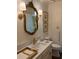 Elegant bathroom featuring a white vanity, decorative mirror, and gold accents at 9301 Brookton Ct, Raleigh, NC 27615