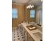 Elegant bathroom featuring a double vanity, patterned wallpaper and black and white flooring at 9301 Brookton Ct, Raleigh, NC 27615