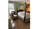 Cozy bedroom featuring four poster bed, hardwood floors, and natural light at 9301 Brookton Ct, Raleigh, NC 27615