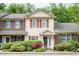 Charming townhome featuring a well-manicured lawn and colorful flowering bushes in front at 942 S Fifth St, Mebane, NC 27302