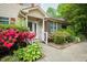 Townhouse entrance with lush landscaping and a covered entryway with white railings at 942 S Fifth St, Mebane, NC 27302