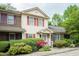 A townhome with neutral siding, colorful shutters, and lush front yard landscaping at 942 S Fifth St, Mebane, NC 27302