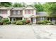 View of a townhome featuring an ample concrete parking area with landscaped shrubbery at 942 S Fifth St, Mebane, NC 27302