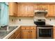 Functional kitchen with stainless steel appliances, light countertops, and wood cabinets at 942 S Fifth St, Mebane, NC 27302