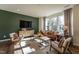Bright living room with a green accent wall, hardwood floors, and large windows at Lot 7 Cooper St, Sanford, NC 27330