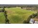 Aerial view featuring a green field dotted with hay bales, trees and home at 1 Deer Run Trl, Hillsborough, NC 27278