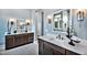 Bathroom with dual sink vanity, white countertop, wood cabinets, and decorative lighting fixtures at 1 Deer Run Trl, Hillsborough, NC 27278