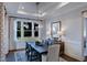 Dining room features modern lighting, neutral decor, and a view of the landscaped backyard through large windows at 1 Deer Run Trl, Hillsborough, NC 27278